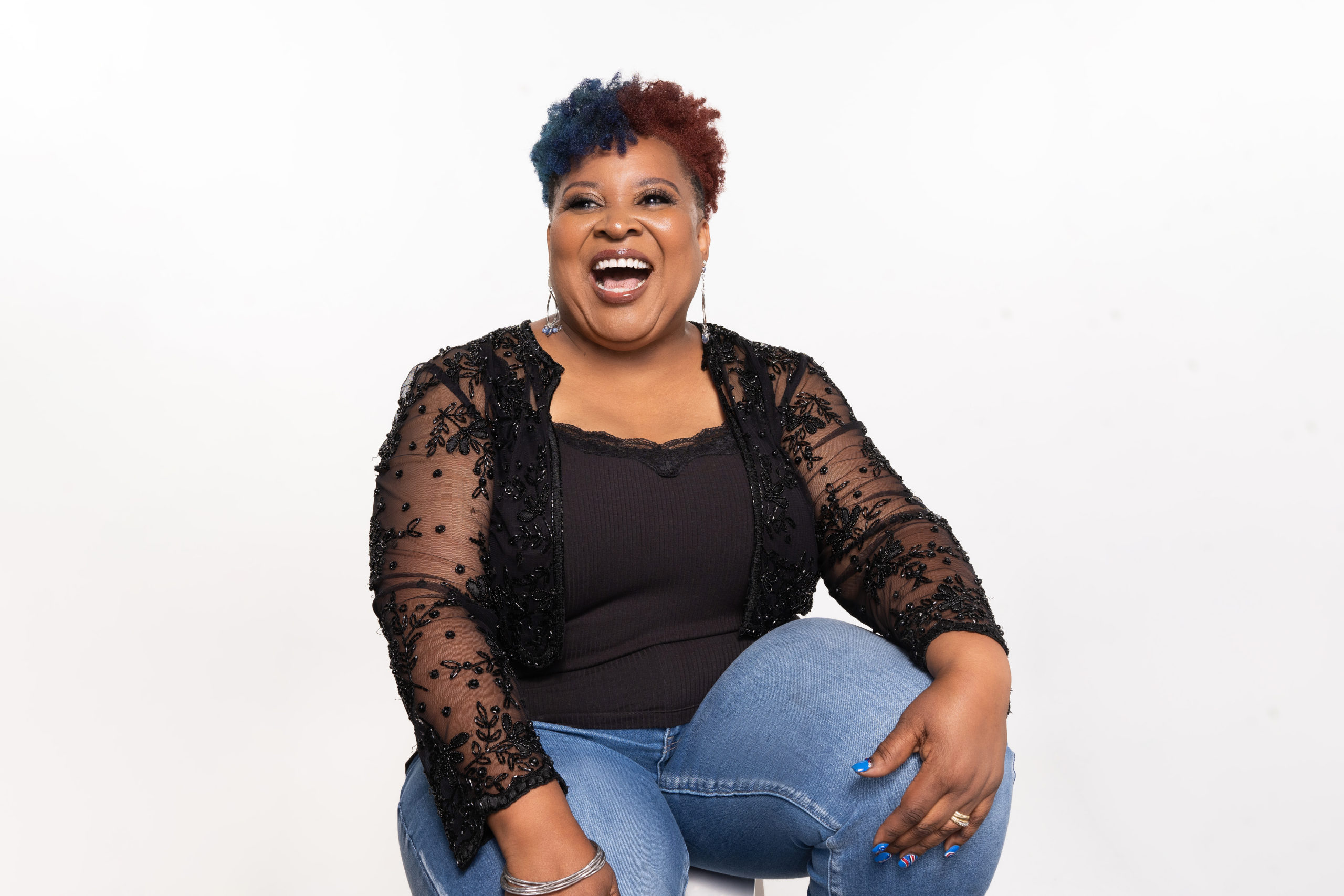Photo of Angela Braxton-Johnson laughing in black top and jeans 