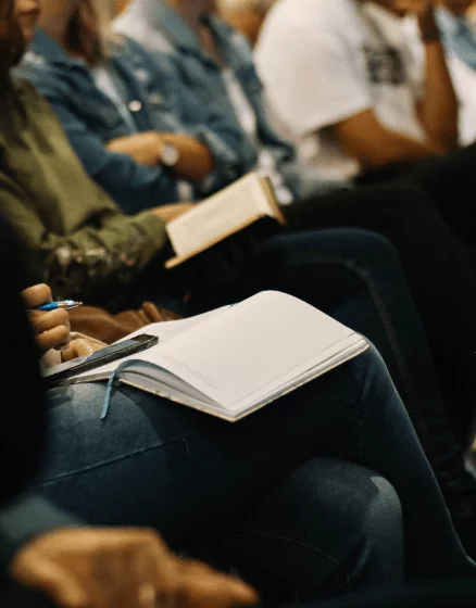 Group of people with notebooks in their laps.